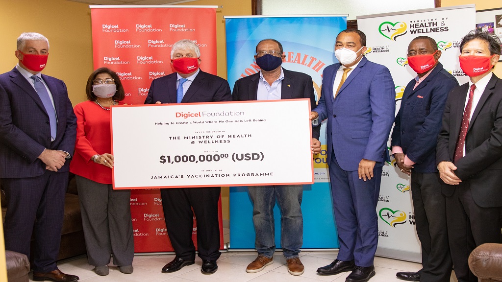 Denis O'Brien, founder and chairman of Digicel, presents a cheque for USD$1 million to Jamaica's vaccination programme