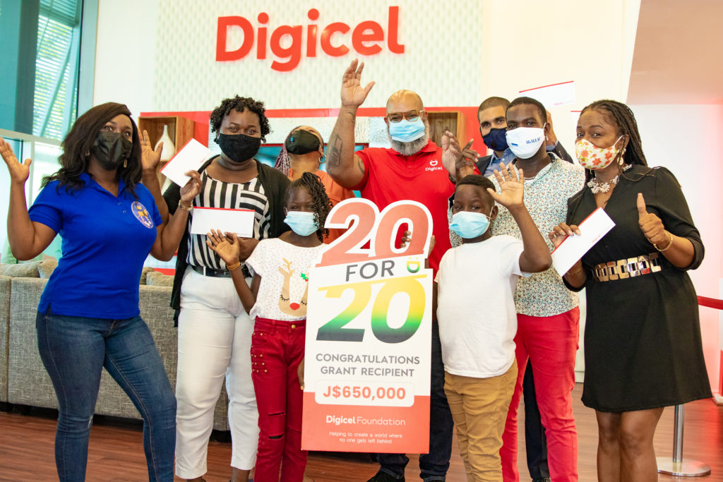 School children with Digicel ‘20 for 20’ grant sign.